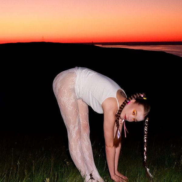 Person stretching gracefully outdoors during sunset.
